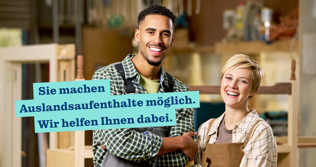 Foto: zwei Personen stehen in einer Schreinerei, die Arme verschränkt und lächeln in die Kamera, Schriftzug: Sie machen Auslandsaufenthalte möglich. Wir helfen Ihnen dabei.