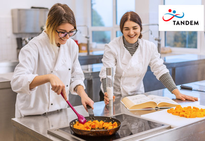 Zwei junge Frauen in Berufsausbildung kochen zusammen in einer Gastronomischen Küche. 