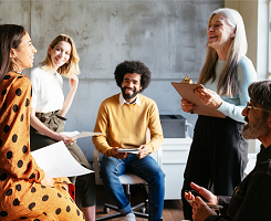 Foto: ein gemischtes Team an Lehrkräften oder Ausbilder/-innen in einer offenen Besprechung.